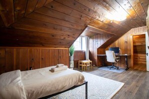 Une pièce en bois avec un lit, un bureau et une chaise.
