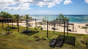 Une terrasse au bord de la plage, avec des sièges extérieurs et une vue sur l’océan.