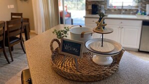 A kitchen counter with a woven placemat, a welcome sign, a decorative starfish, and a small plant. - Oasis home in SW Florida - Heated in-ground pool on a fresh water canal! (Cape Coral)