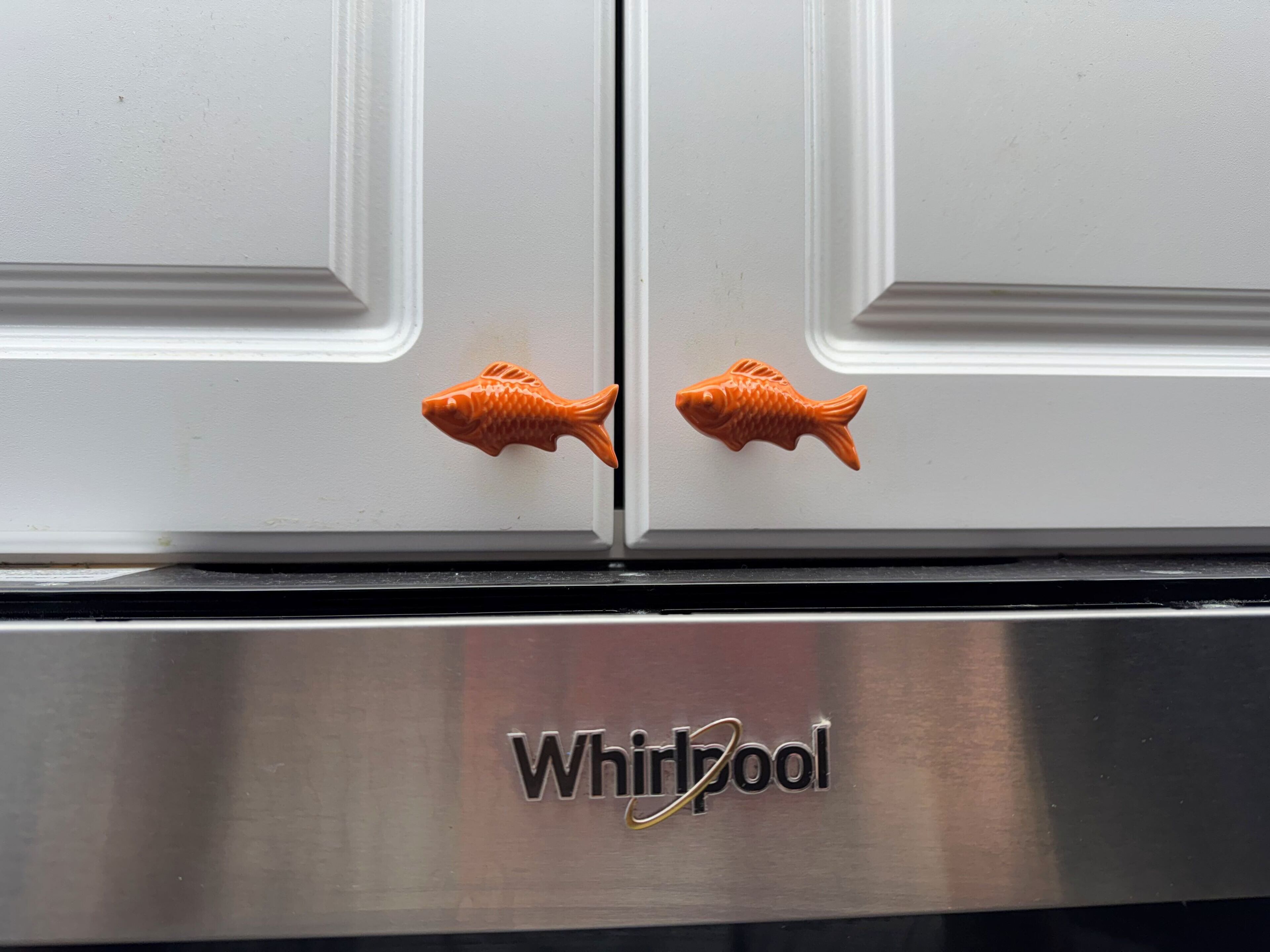 Un refrigerador Whirlpool con dos pomos con forma de pez.
