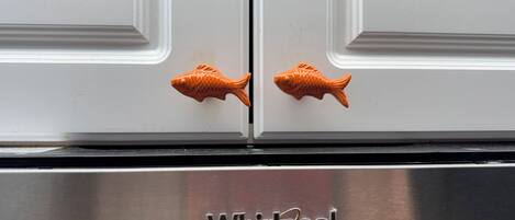 Un refrigerador Whirlpool con dos pomos con forma de pez.