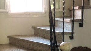 A staircase with granite steps, a wooden handrail, and a white balustrade. - 3-bedroom apartment in the heart of a medieval village in Vallespir (Pyrenees). (Arles sur Tech)