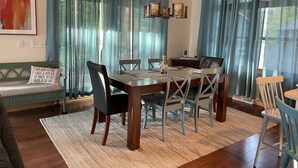 Een eetruimte met een houten tafel, stoelen en een kroonluchter.