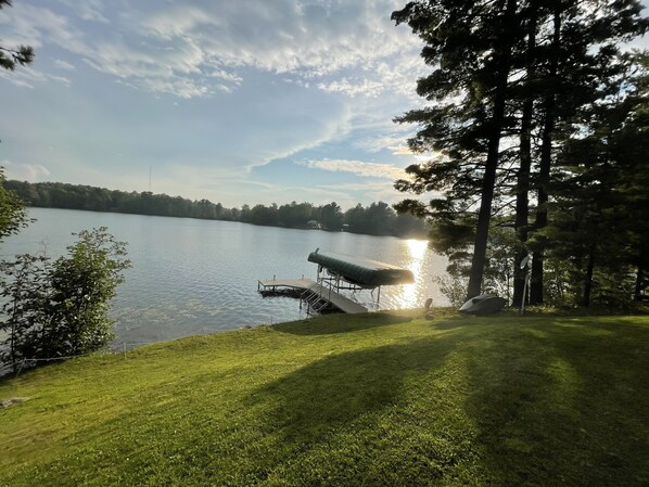 A lakeside view with a dock and a covered seating area.