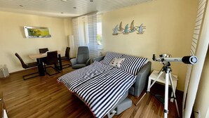 Una habitación con una cama, un escritorio, una silla y un telescopio.
