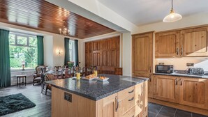 A modern kitchen with wooden cabinets, a granite countertop, and a dining area with a table set for breakfast.