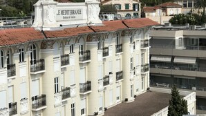 A multi-story building with balconies and a sign reading "Residence de Tourisme".