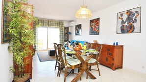 Un espace repas comprenant une table ronde, des chaises et un luminaire suspendu.