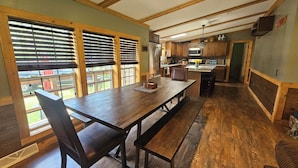 A spacious kitchen with wooden cabinets, a large island, and a dining area with a bench.