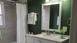 A modern bathroom with a shower, toilet, and sink.