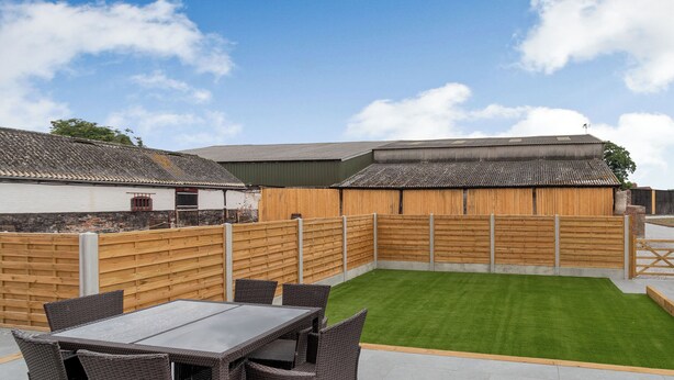 A patio with a table and chairs, a grassy area, and a wooden fence. - Dip Tub Den - UK35989 (Skerne, near Driffield)