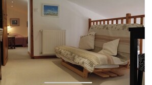 Ein gemütliches Zimmer mit einem hölzernen Bett, einem Heizkörper und einem kleinen Tisch mit einer Lampe.