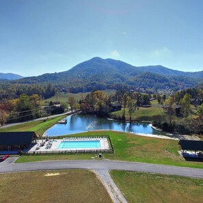 A swimming pool with a view of a lake and mountains.
