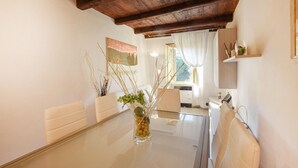 Une cuisine moderne avec une table en verre, des armoires blanches et un plafond en bois.
