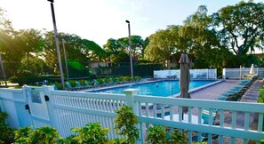 A pool area with a white fence, lounge chairs, and a covered seating area. - Shorewalk The Palm Condo 2Bed/2Bath Close to IMG / Beach (Bradenton)