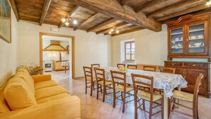 Un comedor con una mesa de madera, sillas y un aparador con puertas de cristal.