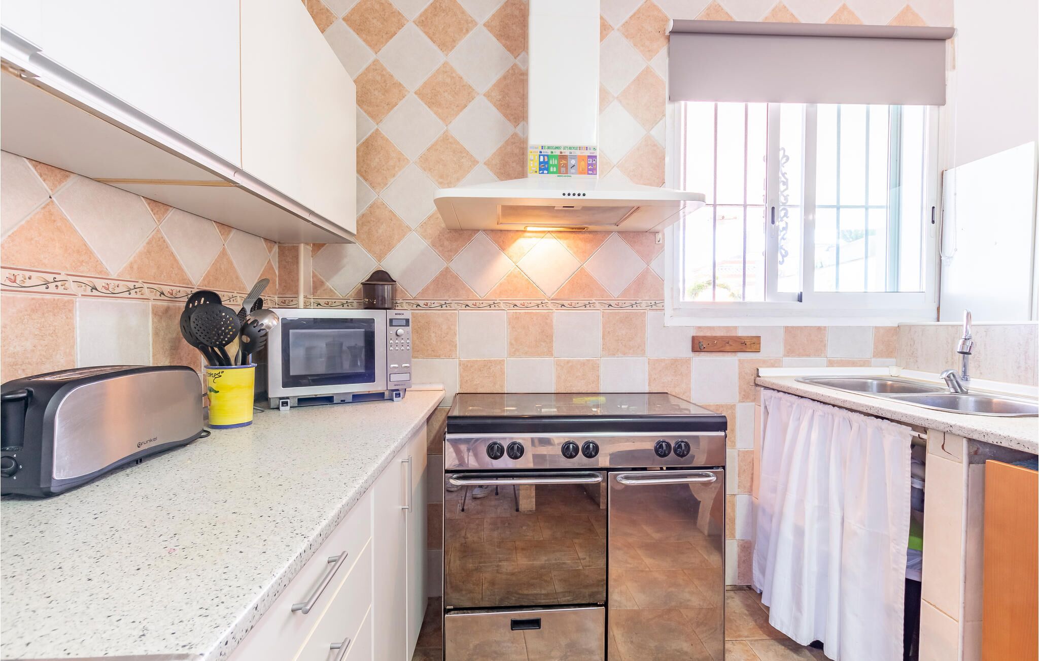 A compact kitchen with a gas stove, a microwave, and a toaster.