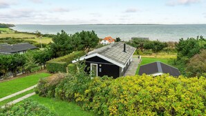 A coastal property with a house featuring a sloped roof, a deck, and a view of the sea. - Awesome home in Faaborg with WiFi (Faaborg)