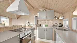 Una cocina moderna con detalles de madera, un horno Bosch y un lavavajillas.