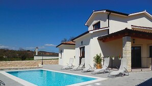 A two-story house with a swimming pool, outdoor seating, and a stone wall. - Stunning home in Labin (Labin)