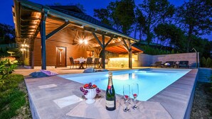Una piscina con zona de comedor y bar.