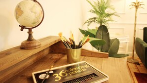 A wooden desk with a globe, a set of 36 colored pencils, and a plant. - ARTstudio 2.0 Superior 2-bedroom apartment with terrace. Near IGA 27! (Duisburg)