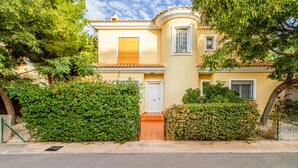 A two-story building with a yellow facade, a white door, and a small balcony. - Awesome home in Alacant with WiFi (Alacant)