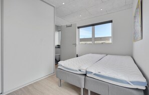 Relax in this serene bedroom with a single bed and a large window offering a view of the outside.