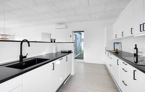 Enjoy cooking in this well-lit kitchen with a large sink, oven, and ample storage.