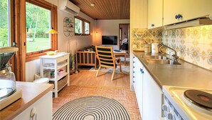 A compact kitchen with a stove, sink, and dining area. - Cozy home in Perstorp with WiFi (Perstorp)