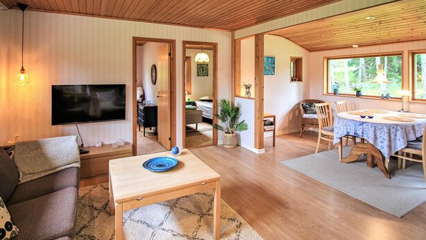 A spacious living room with a TV, a dining area with a table and chairs, and a cozy seating area with a sofa. - Cozy home in Perstorp with WiFi (Perstorp)