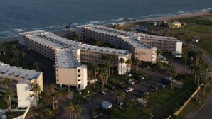 Um hotel à beira-mar com vários edifícios, zonas de estacionamento e vista para o oceano.