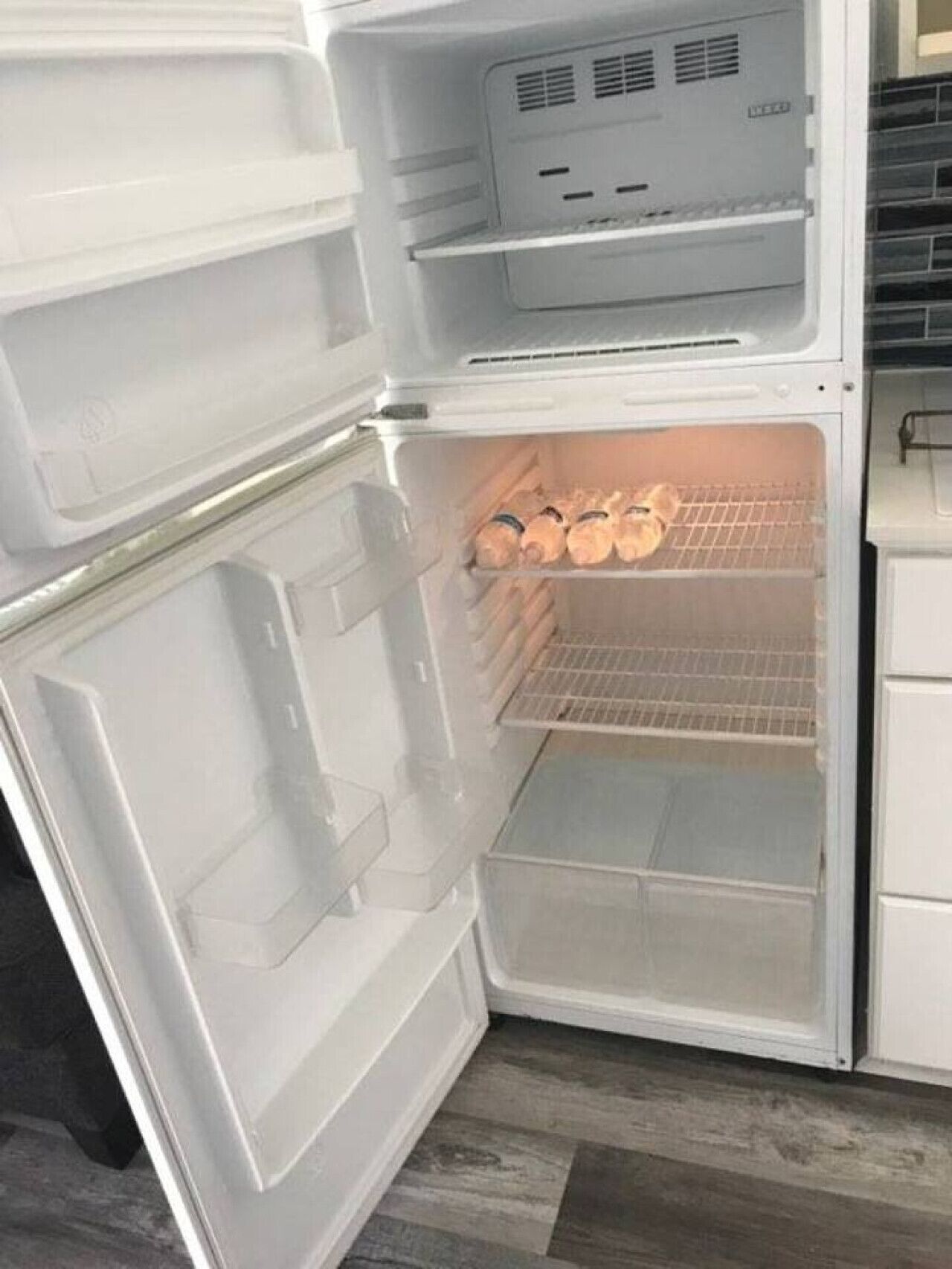 An open refrigerator with two shelves and a freezer compartment.
