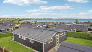 A residential area with houses, a flag, and a body of water in the background. - 4 bedroom cozy home in Rønde (Rønde)