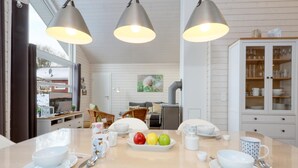 A dining area with a table set for four, a white cabinet with glass doors, and a large window with curtains. - Amazing home in Krems II/Warderbrück with sauna (Krems II/Warderbrück)