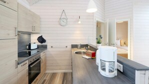 A modern kitchen with wooden cabinets, a built-in oven, a coffee machine, and a sink. - Amazing home in Krems II/Warderbrück with sauna (Krems II/Warderbrück)