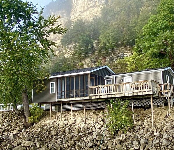 Een chalet met terras en uitzicht op een rotsachtige klif.