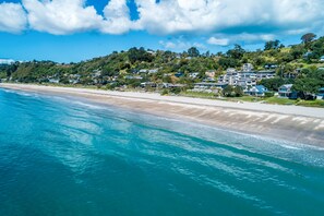 A coastal area with a beach and houses on a hillside.