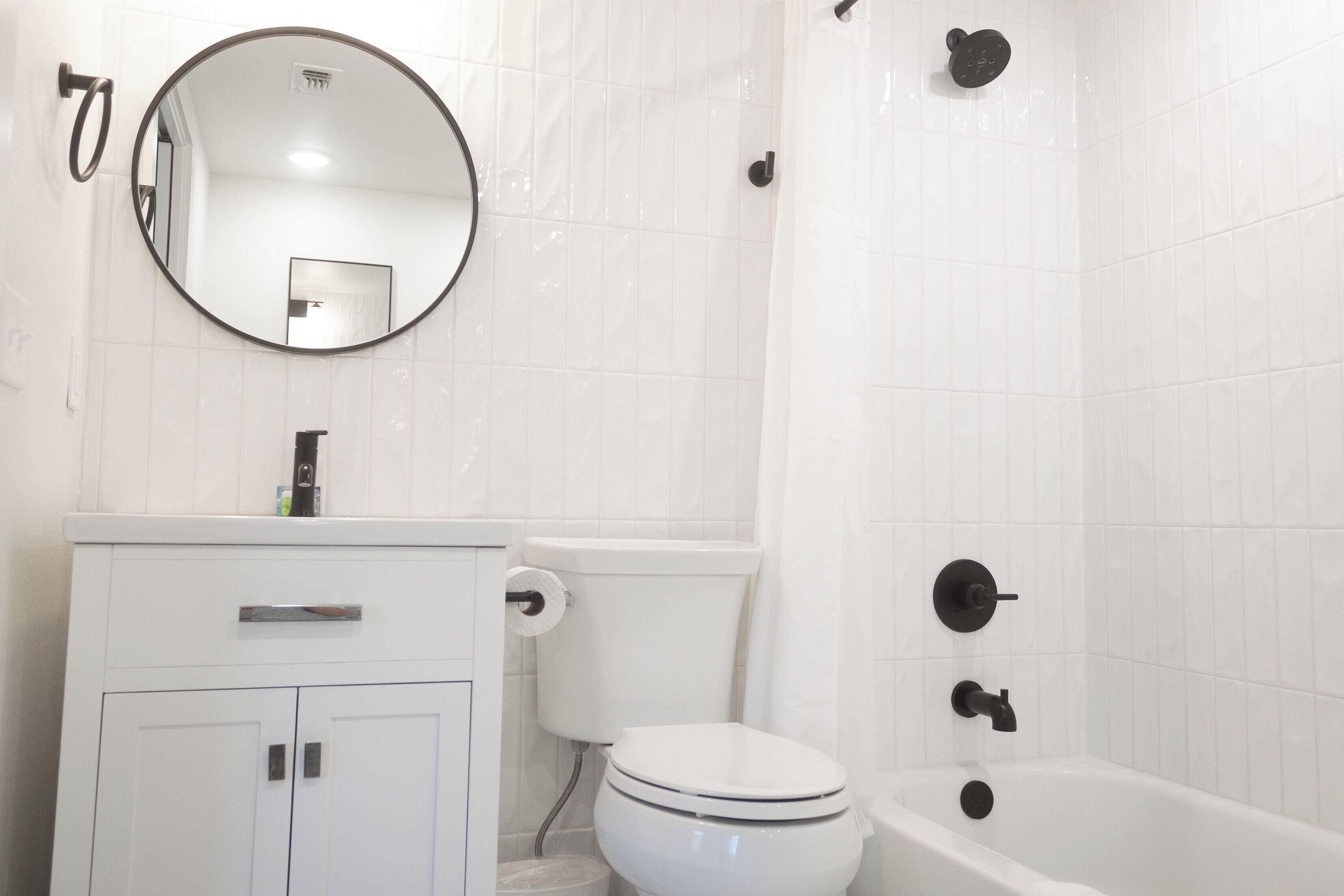 Un bagno con servizi igienici, lavabo, specchio e vasca da bagno.
