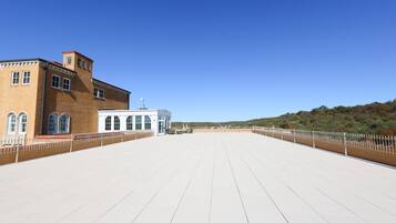 A large, open deck area with a clear view of a building with arched windows and a red roof.