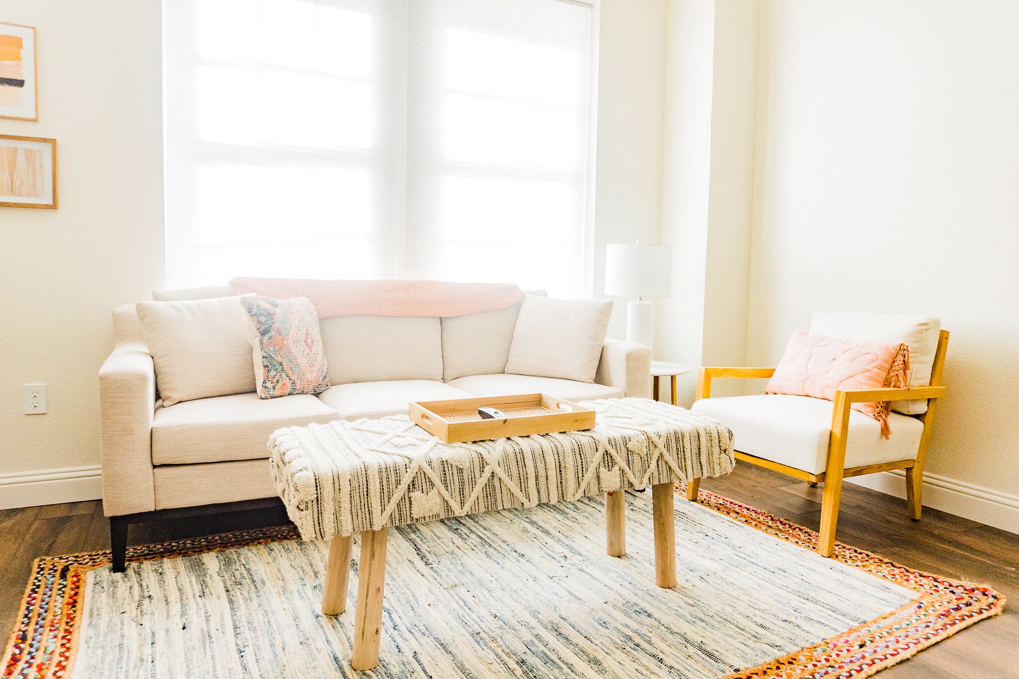 Una sala de estar con un sofá, un sillón, una mesa de centro y una alfombra estampada.