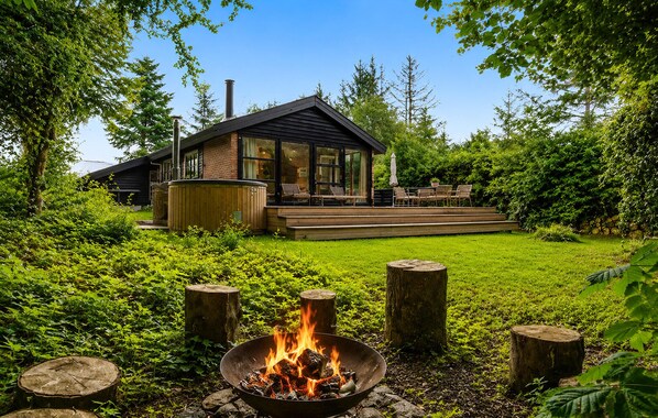 A modern house with a deck, a fire pit, and a lush garden. - Gorgeous home in Hadsund with WiFi (Hadsund)
