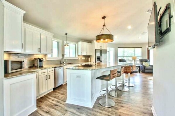 Enjoy meals in this well-equipped kitchen with a central island, sink, and stainless steel range hood.