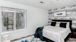 A bedroom with a bed, a window, and a wall-mounted picture. - Spacious 2,500 Sq Ft Wichita Home -3 Showers-2 Tubs-Near Base & Arena (Wichita)