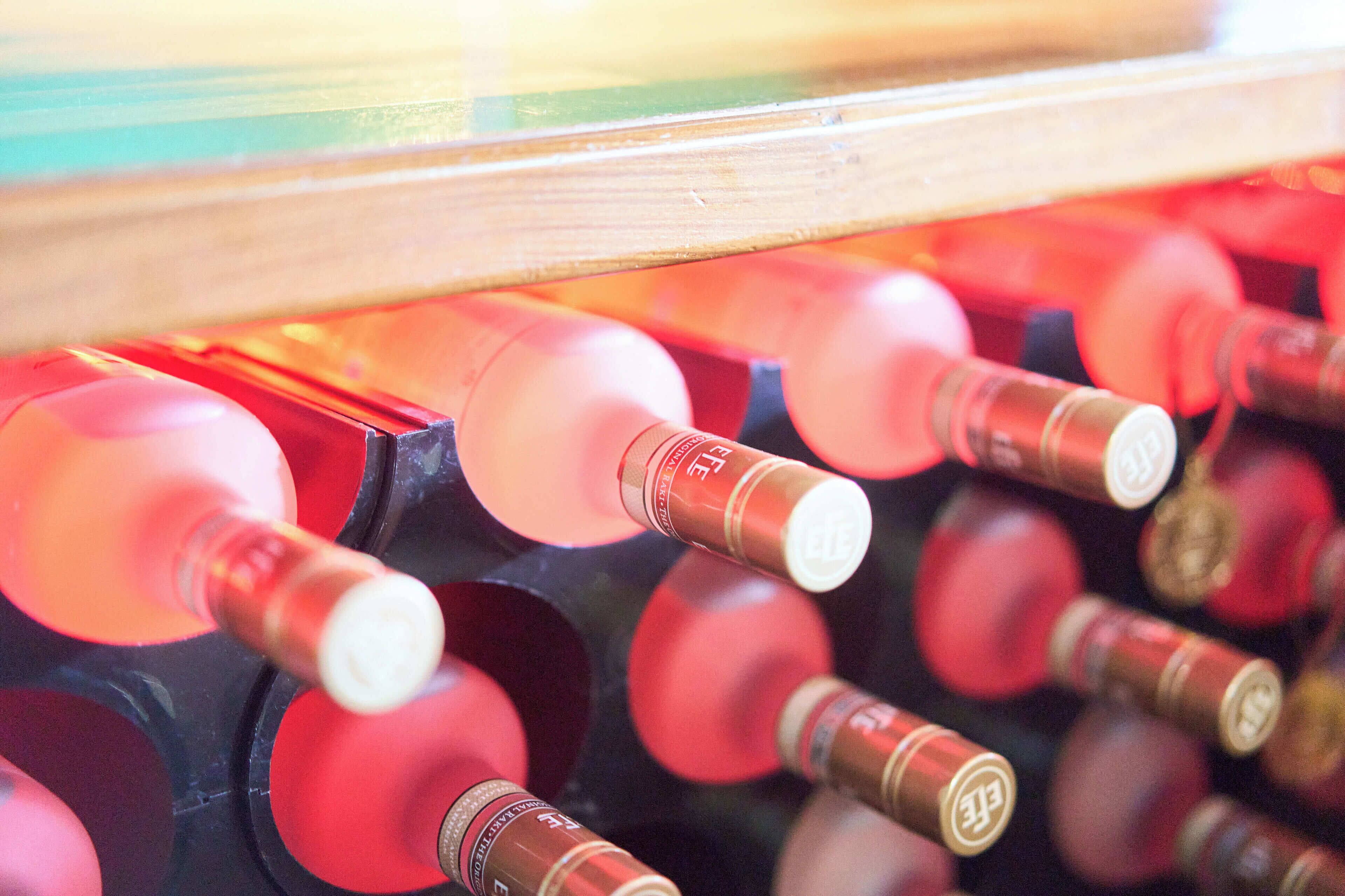 Botellas de vino con corchos, dispuestas en una caja de madera.
