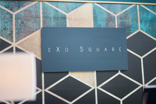 A sign with the text "EXO SQUARE" on a wall with a geometric pattern. - eXo Square Heidelberg-Schwetzingen - By SuperFly Hotels (Schwetzingen)