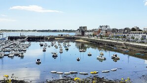 A harbor with boats docked, a bridge in the background, and buildings along the waterfront. - 2 bedroom gorgeous home in Concarneau (concarneau)