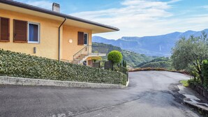 Una casa amb un balcó, una escala i vista a les muntanyes.