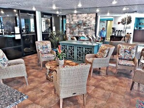 Relax in this inviting seating area with wicker chairs and a central table, surrounded by potted plants and decorative accents.