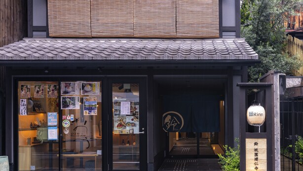 Ein Restaurant mit traditionellem japanischen Eingang, einem Schild und einem Ziegeldach.